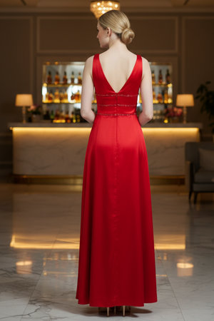 Woman in a red evening gown standing in a luxurious room with a bar in the background.